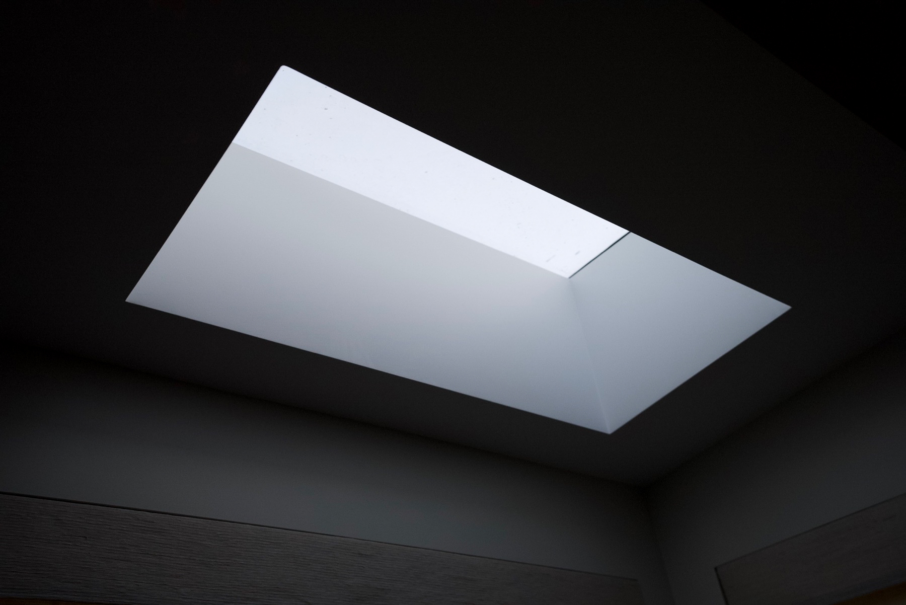 Dark room with glowing skylight